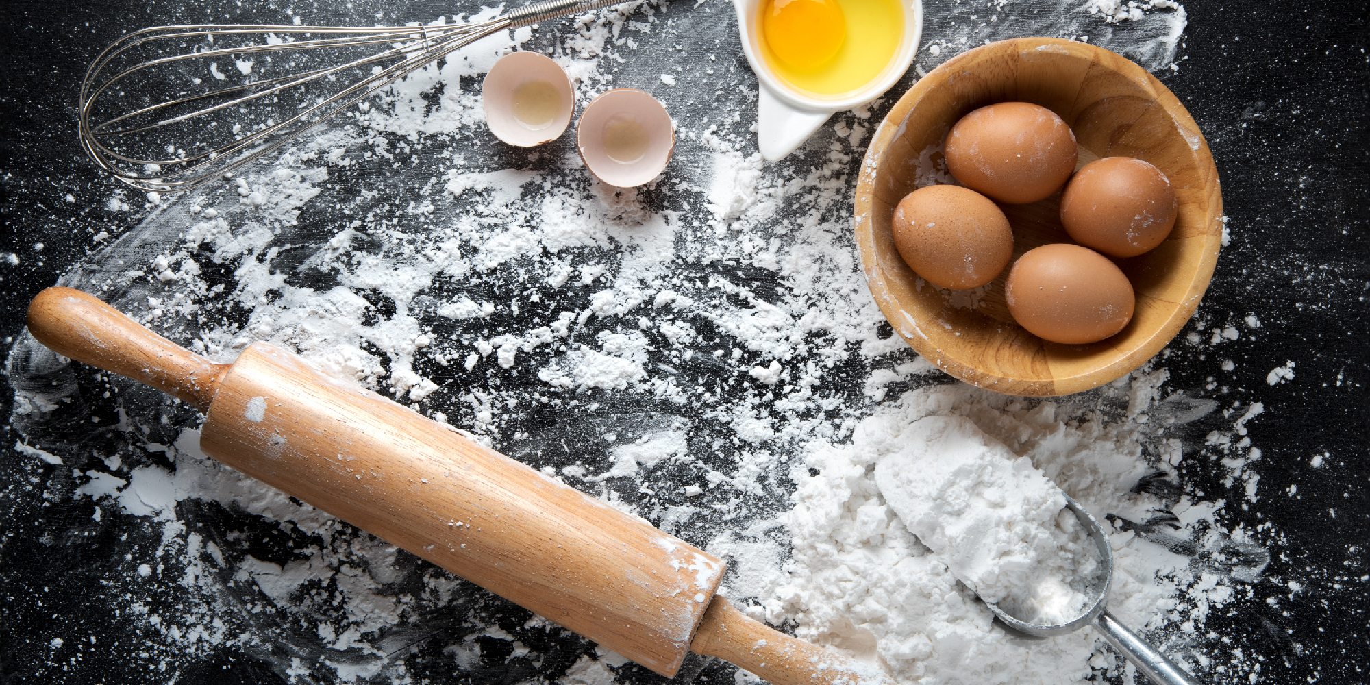baking ingredients flour cracked eggs and rolling pin