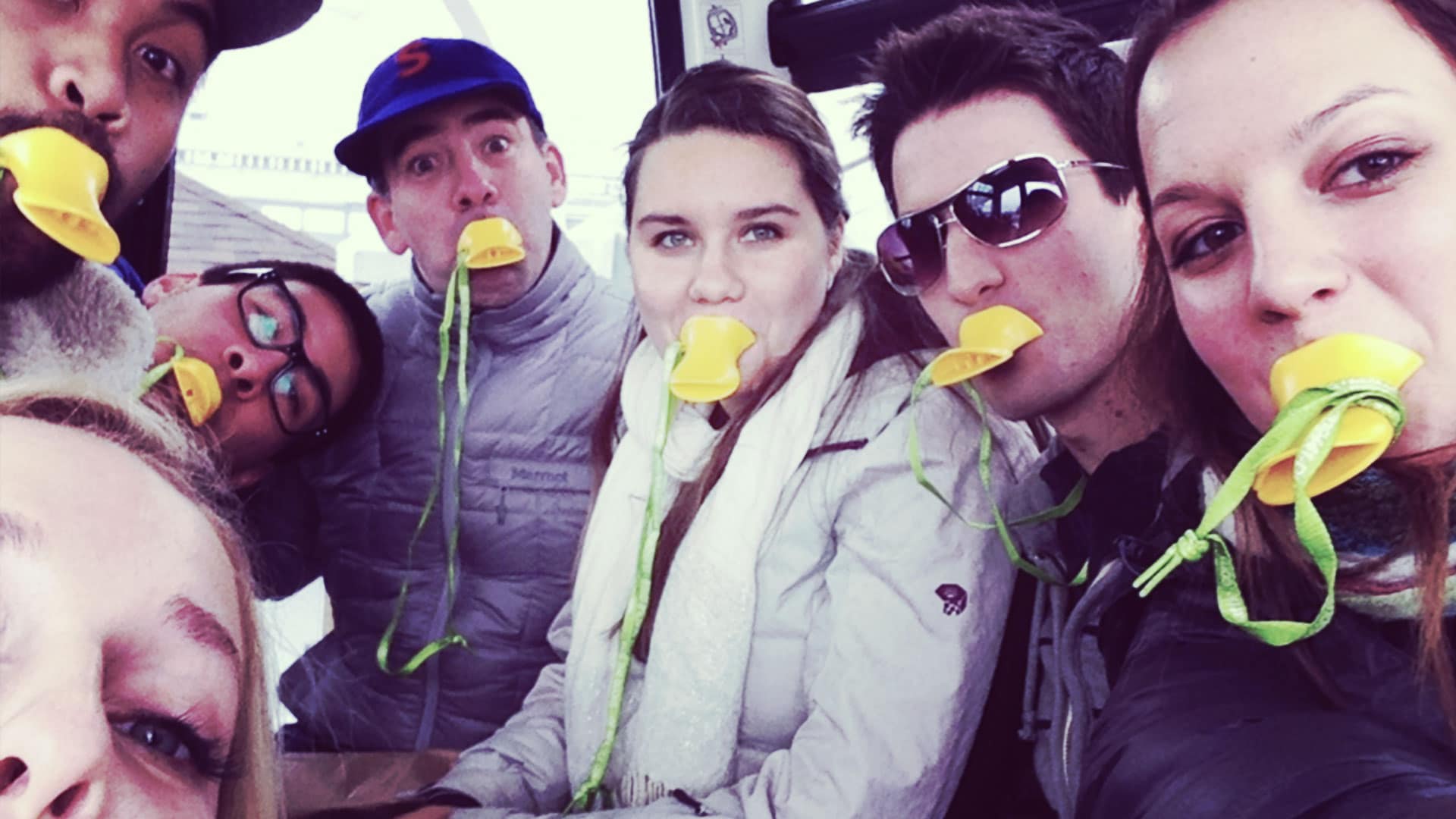 photo of people with yellow duck calls in their mouths