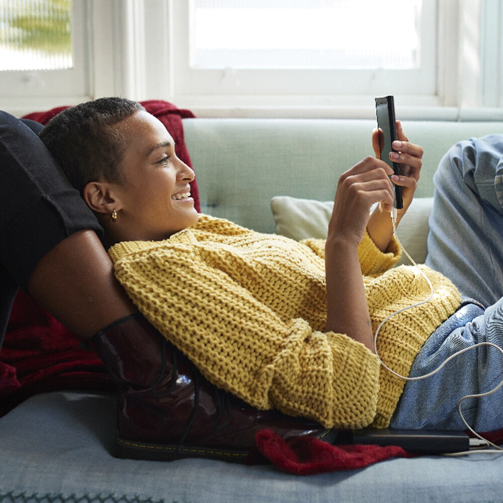 woman on couch using smartphone